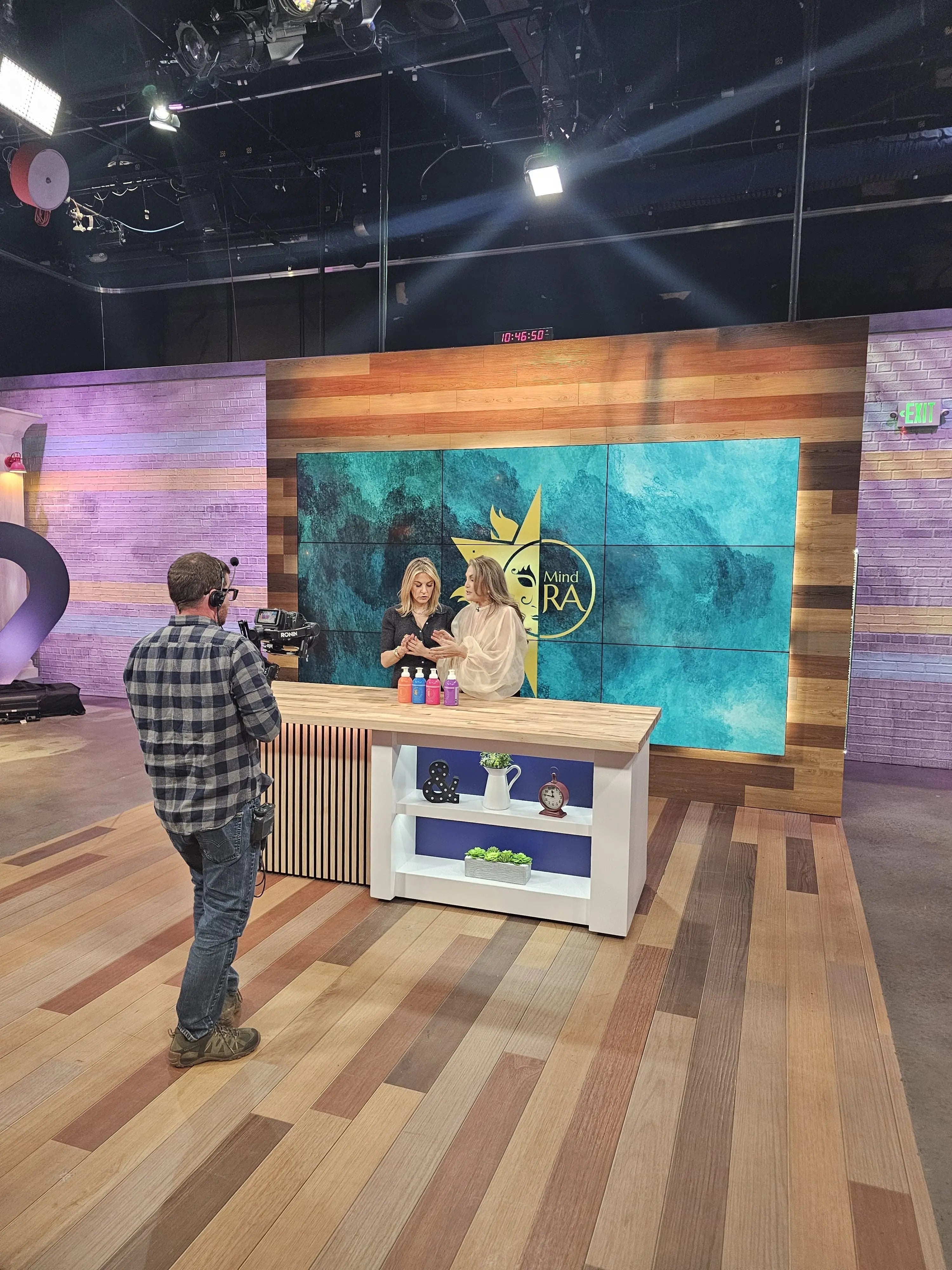 Behind-the-scenes studio filming of a mental health brand segment on 9News Denver, featuring Mind-Ra products on set during a televised interview and media feature.